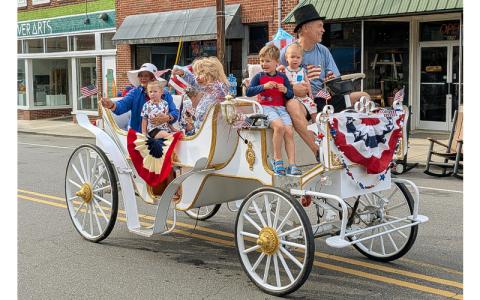 MNJ Photos/Steffen Silvis.  A horseless carriage takes to Upper Street (Oak Avenue) adorned with patriotic bunting. 