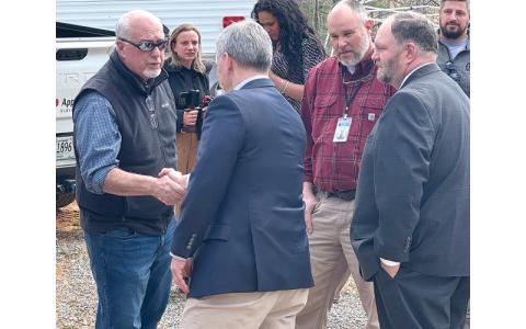 MNJ Photo/Jaren Gragg.  Gov. Josh Stein greets local government officials in Bakersville. Stein visited a home reconstruction site and spoke about disaster recovery.