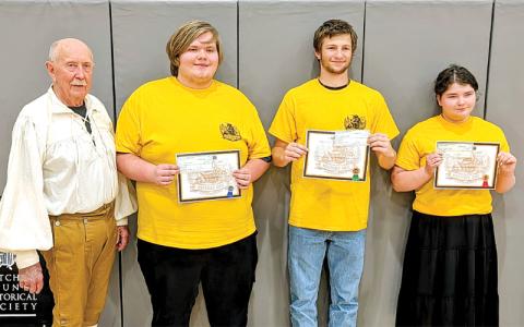 MNJ Photo/Steffen Silvis.  Dr. Daniel Barron, the chair of the Mitchell County Historical Society, stands next to the Mitchell County History Bee’s high school winners. From left are Connor Miller (second place, Mayland Early College), Sam Jones (third place, Mitchell High School), and Grace Smith (first place, Mitchell High School).