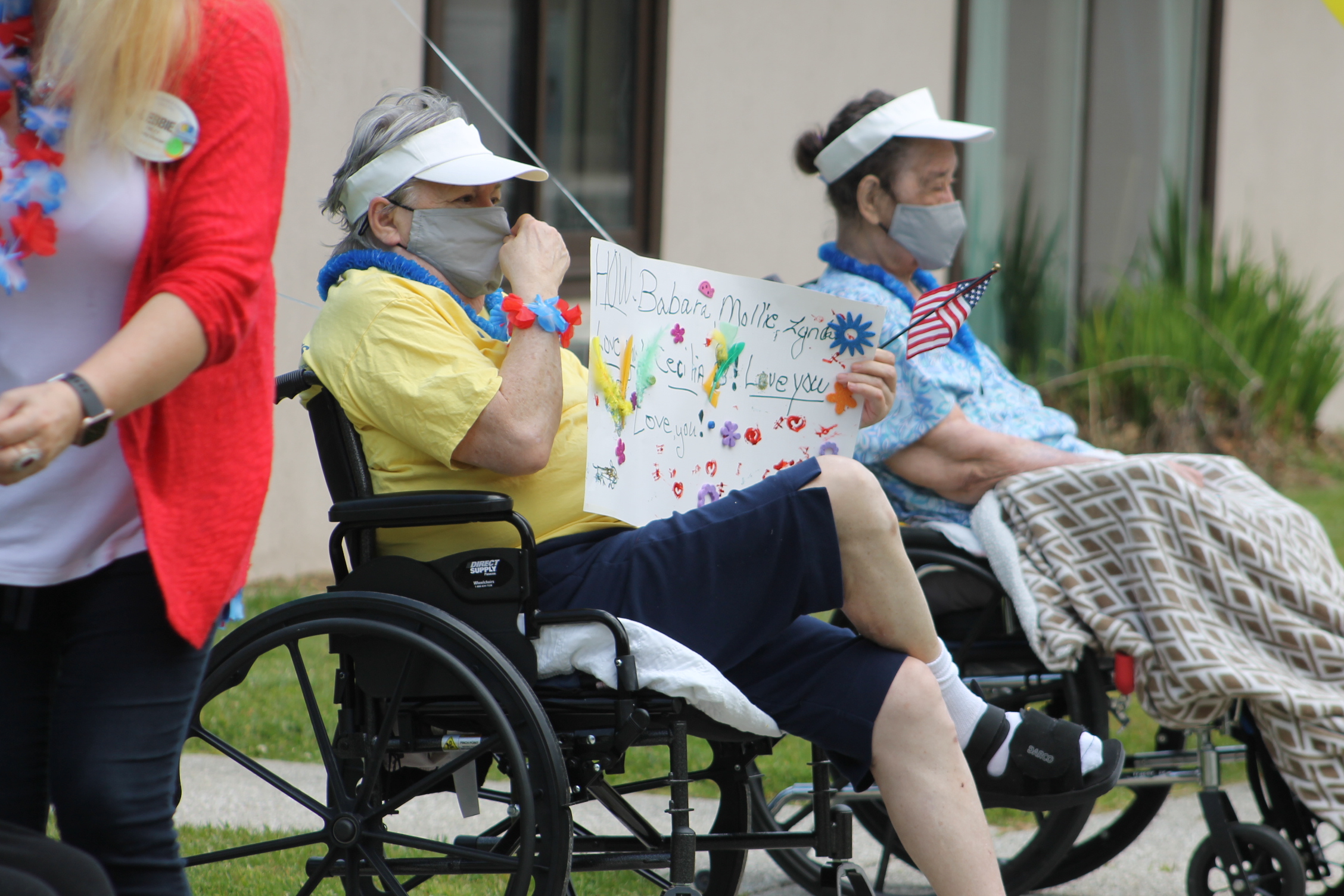 A Brian Center Resident enjoys the parade along with a hand-made sign with names of family members and the words "Love you." (Photos by Juliana Walker/MNJ)