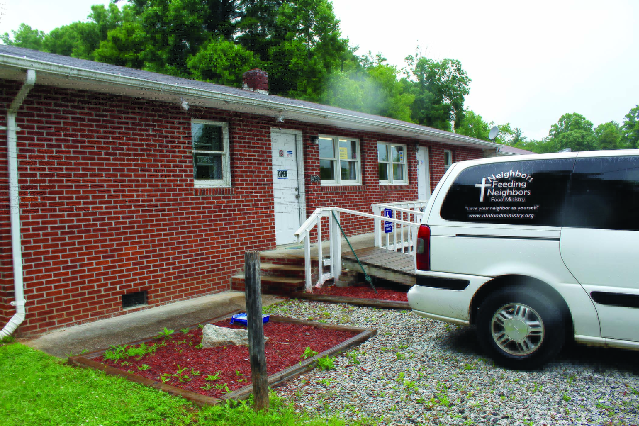 Neighbors Feeding Neighbors food ministry has found a new home in Spruce Pine. The building sits ready for visitors with the ministry van parked outside. Photo by Cory Spiers/MNJ.