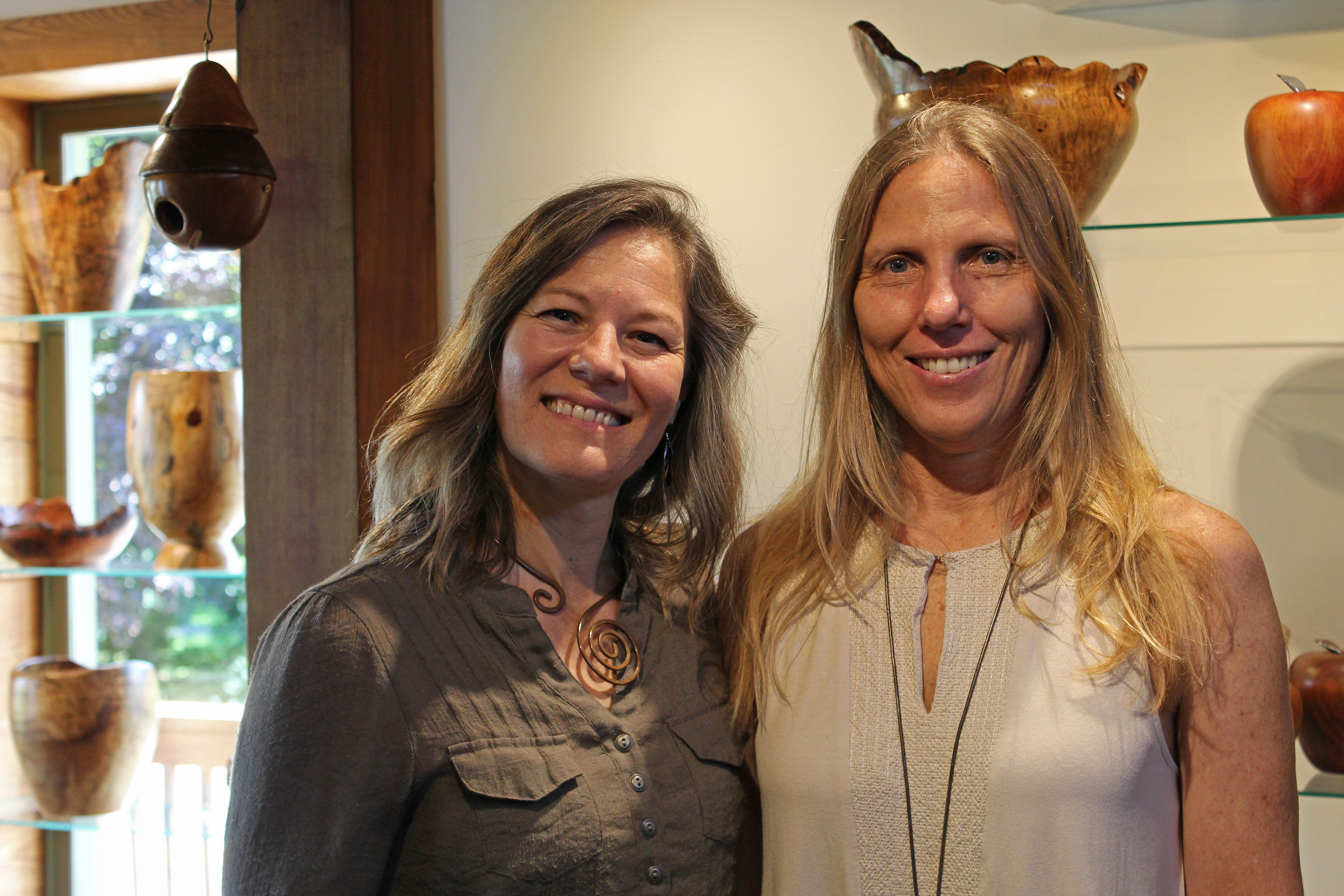 Sweetgrass Artisan Mercantile co-owners Jessica Charapata (left) and Melissa Andersen (right) smile and pose for a photo inside of their new gallery in Bakersville. (MNJ photo/Juliana Walker)