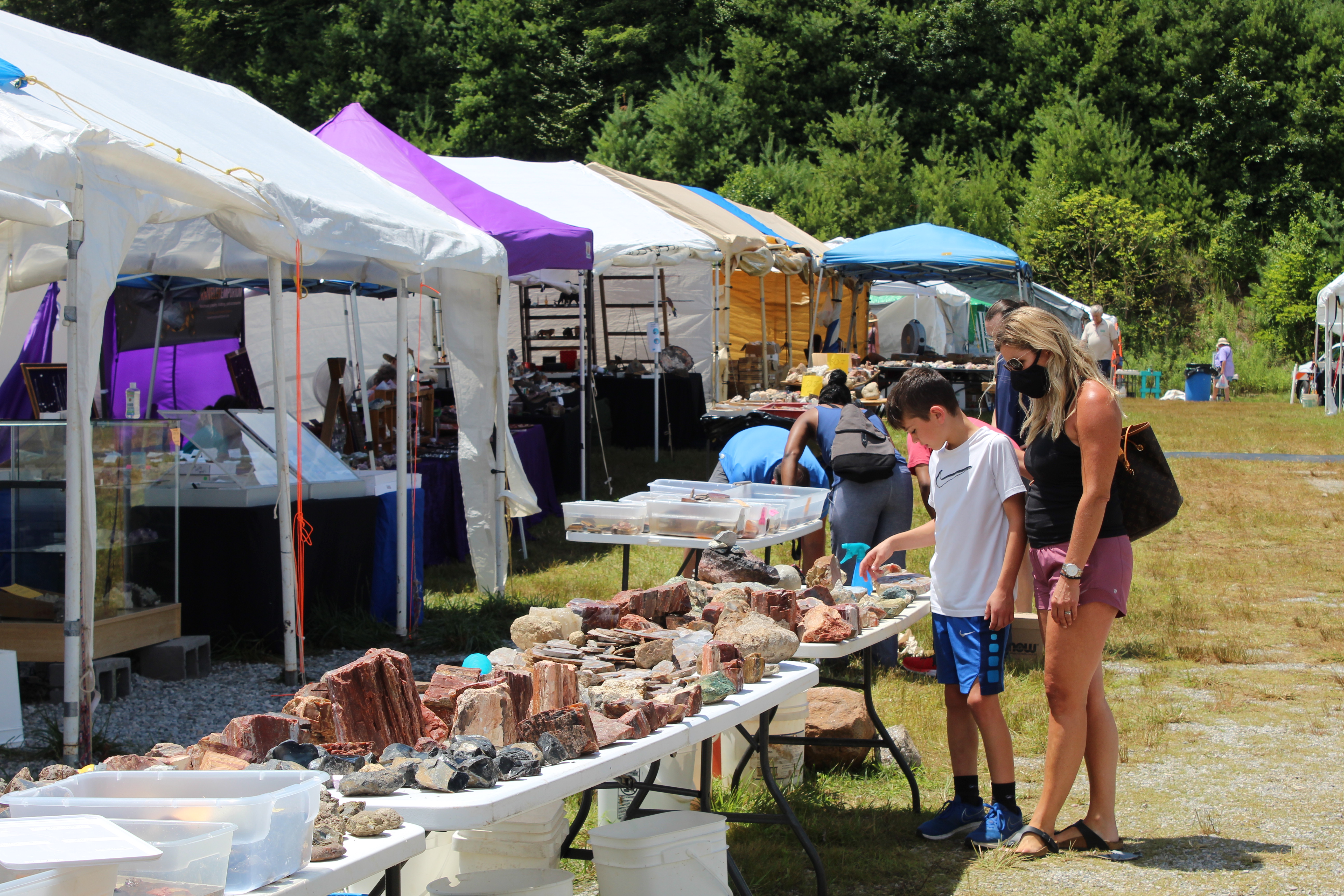 Guests at the Grassy Creek Gem and Mineral Show browse the wares of one of the show’s vendors Friday, July 31. (MNJ photo/Juliana Walker)