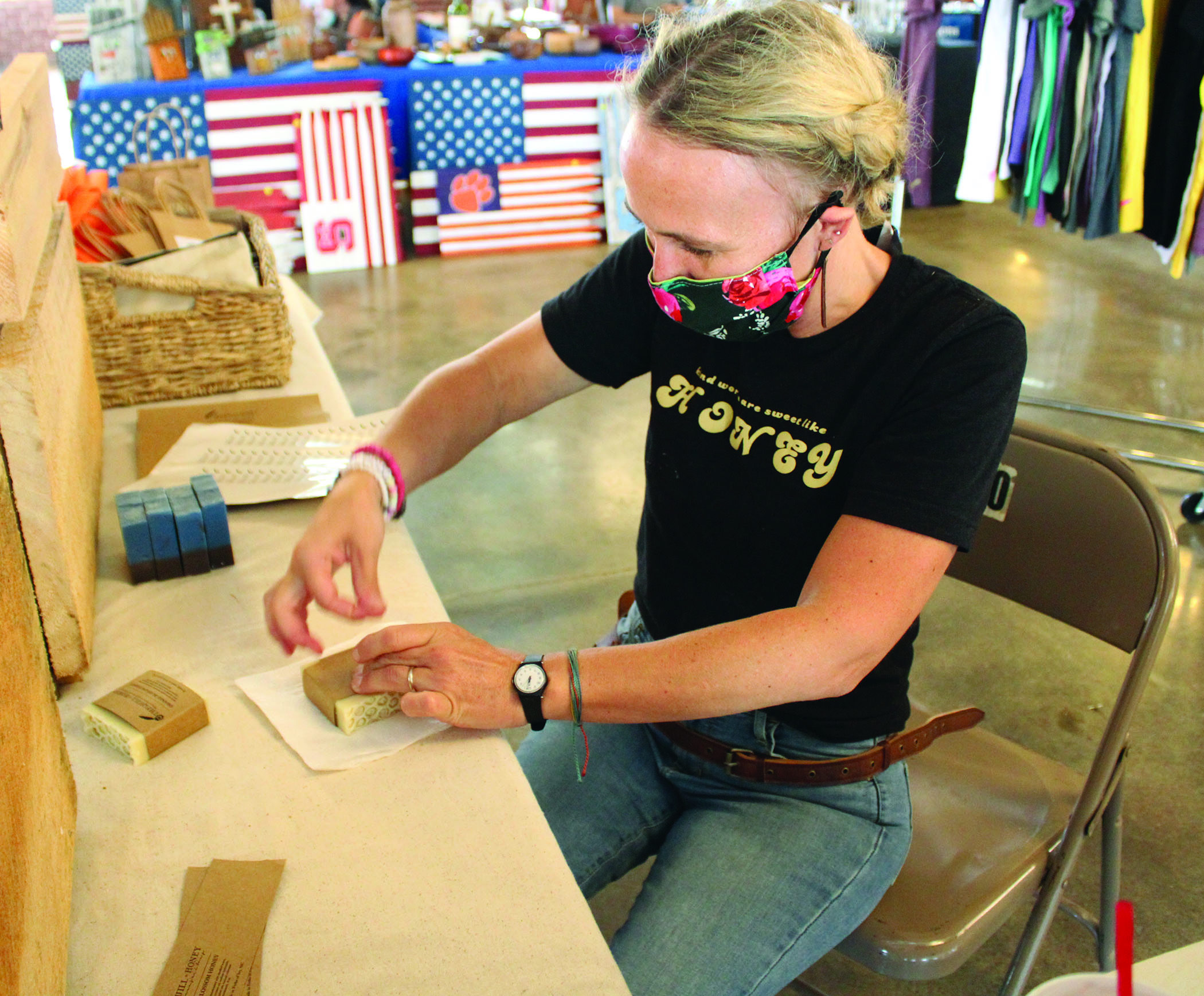 Kendall Chandler, owner and developer of The Quill and Honey, wraps up soap bars to prepare them for sale Friday, July 31 during the Rock Hound Craft and Vintage Market at Cross Street Commerce Center. Chandler came to the show from Forks of Ivy. (MNJ photo/Cory Spiers)