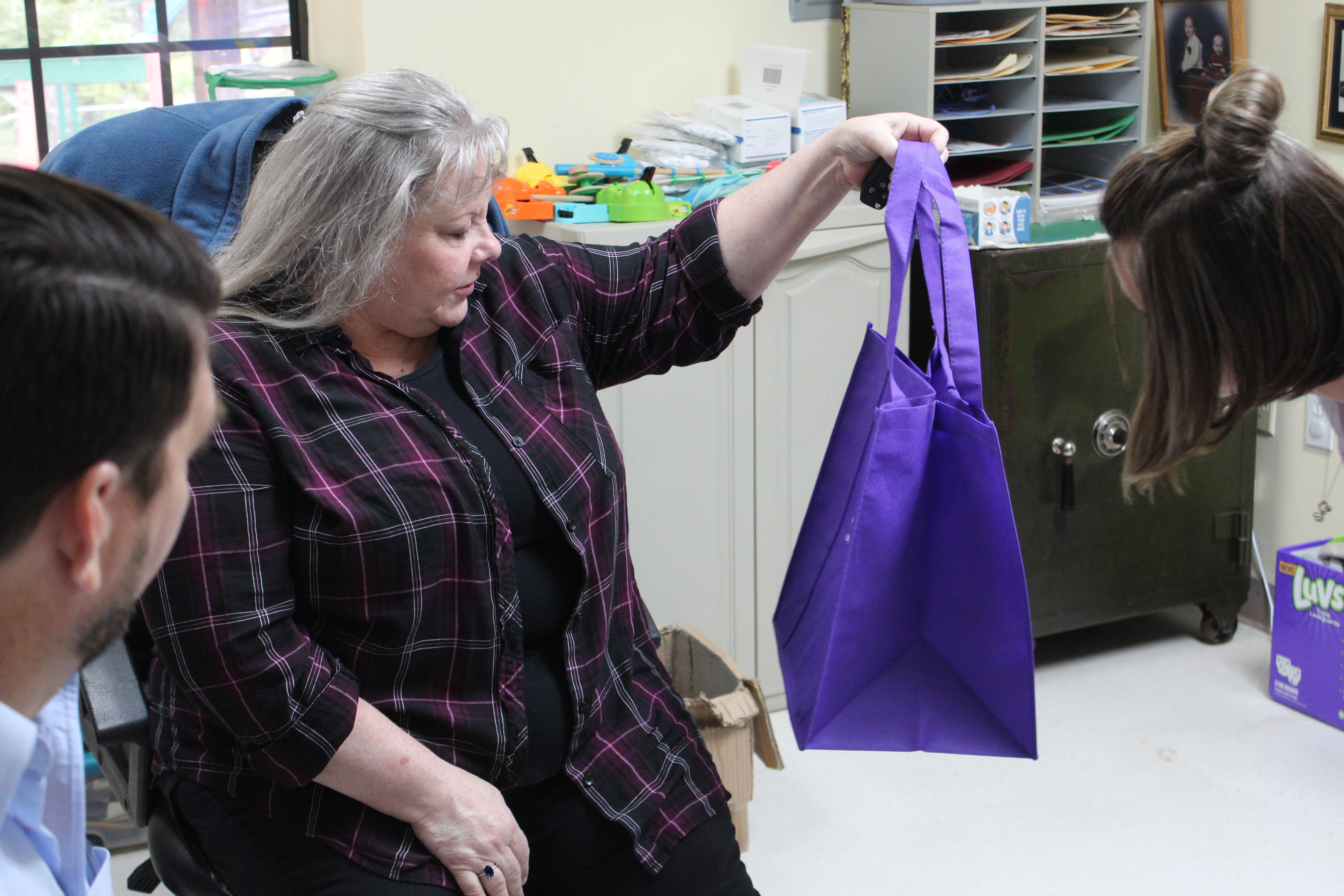 DSS Adoption and Licensing Worker Donna Davis gets at closer look at one of the bags that Hollifield’s Christian Child Care Center donated to the department.  (MNJ photo/Juliana Walker) 