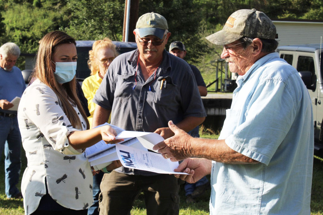 Halley Burleson hands out fliers to local residents at the special meeting Tuesday, Aug. 25. (MNJ Photo/Juliana Walker)