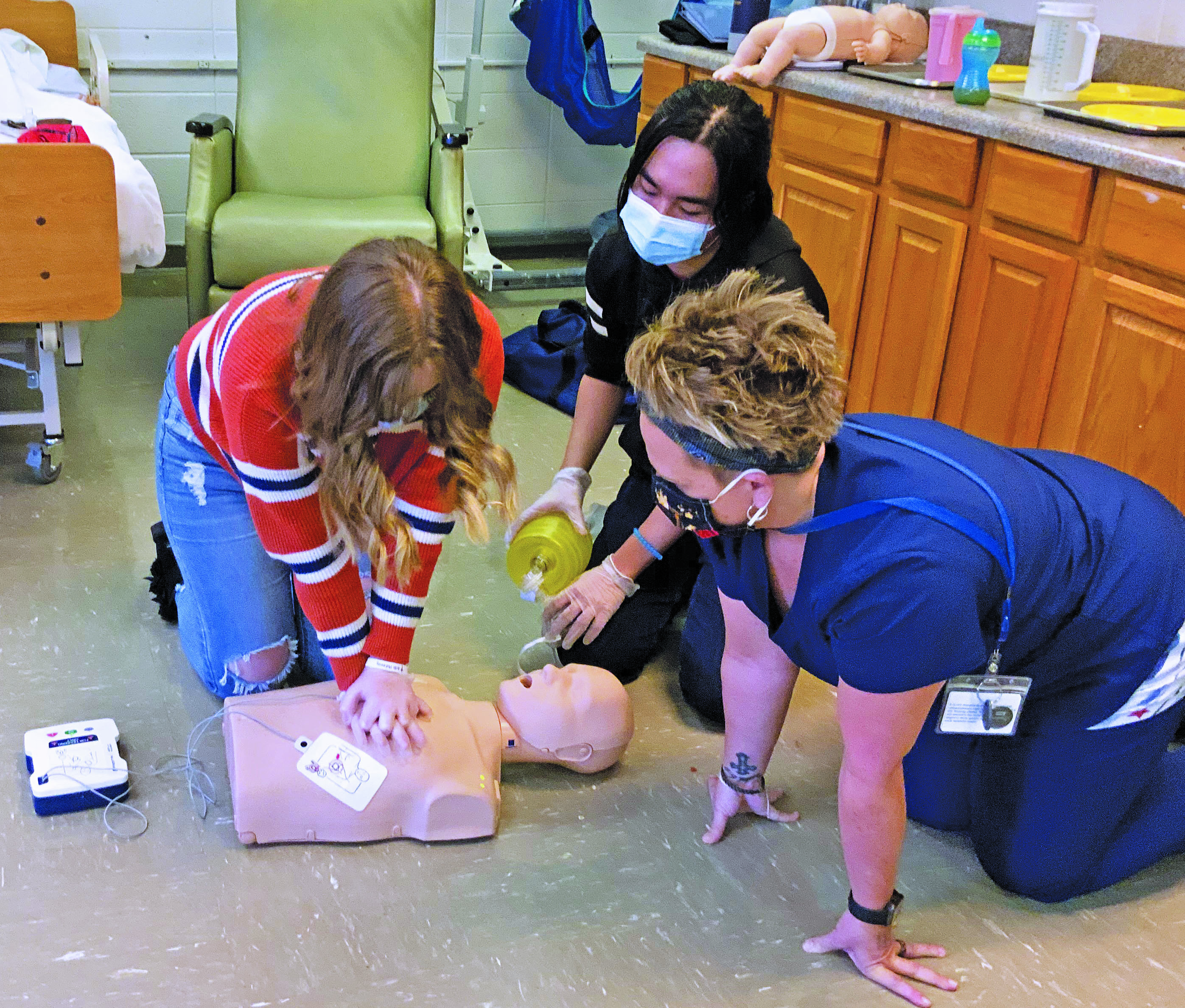Shannon Tipton of Hospice, Palliative and CAP of the Blue Ridge looks on as Mitchell High School students perform adult and infant CPR. Tipton helped 35 students earn their CPR certification through hands-on training and testing. (Submitted)