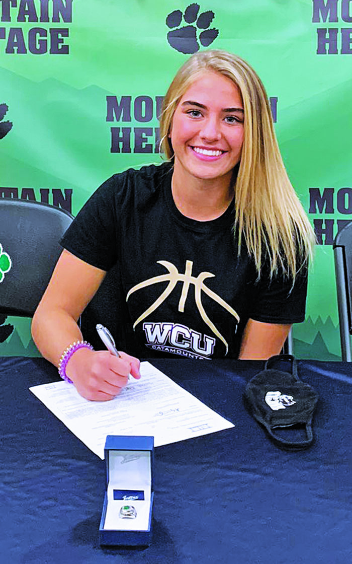 Heritage senior Hannah Tipton puts pen to paper on her commitment to Western Carolina. Her grandfather was instrumental in Mitchell County recreation league sports. (Submitted)