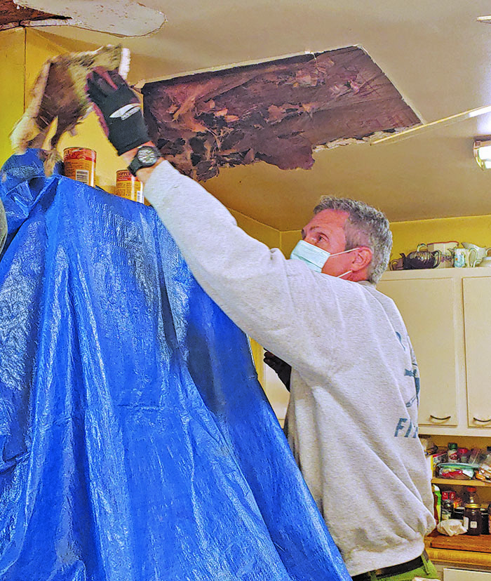 This past fall, volunteers from Spruce Pine United Methodist Church rallied to support a local senior with roof repairs. Volunteers restored the ceiling where water levels had caused damage. Pictured above repairing the ceiling is volunteer Mike Murphy. (Submitted photo)
