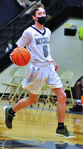 Senior guard Jeremy Sparks dribbles up the court and surveys the situation as he prepares to make a pass during a home game against Owen on Wednesday, Feb. 3. (Photo by Tessa Taylor)