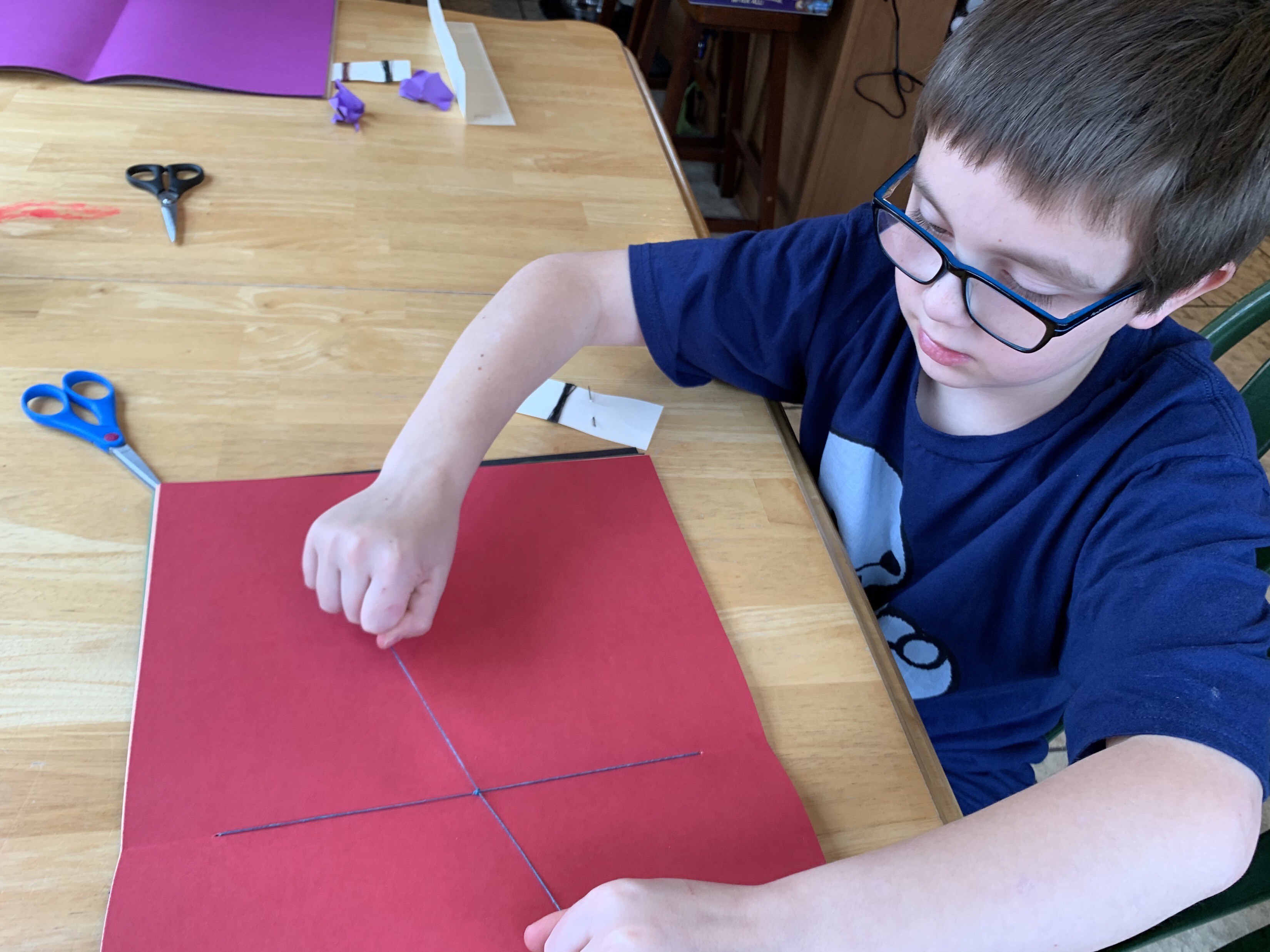 Ezra McClure, a student in Michelle Stafford’s third-grade class at Deyton Elementary, sews the pages of his moon journal. Students and teachers were forced to adapt to the new virtual format this year. (Submitted)