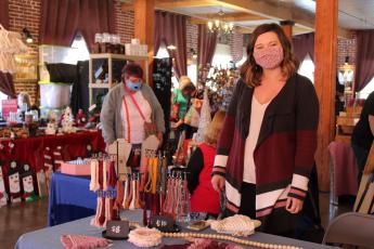 Mitchell County native Brittney King keeps watch over her booth at the Spruce Pine Southern Christmas Show on Saturday, Nov. 28 at the Cross Street Commerce Center. King, who heard about the show from a fellow craftsman, was one of 40 vendors set up at the show. (MNJ photo/Juliana Walker)