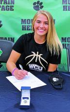 Heritage senior Hannah Tipton puts pen to paper on her commitment to Western Carolina. Her grandfather was instrumental in Mitchell County recreation league sports. (Submitted)