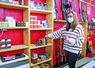Mountaineer Pawn Shop co-owner Sonya Wheeler prepares to pick up a box of ammo off of a shelf in her store to sell to a customer. The shop’s shelves and cases were stocked with some ammo on Tuesday, Jan. 5 but Wheeler expects it will move quickly, as her ammo does these days. (MNJ photo/Cory Spiers)