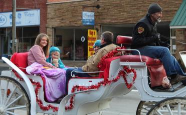 The Jones family smiles as they enjoy a carriage ride through downtown Spruce Pine on Saturday, Feb. 13. The rides were part of a promotion from the Mitchell Chamber of Commerce that encouraged folks to shop local. The Jones family consists of April, Brandon, Finley and Audrey. (MNJ photo/Juliana Walker)
