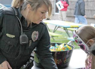 Office Tara Arnett with the Spruce Pine Police Department handed out candy to hundreds of trick-or-treaters on Saturday night. While some kids were dog-gone-tired, others enjoyed the candy shoot at DT’s Blue Ridge Java. Parents and kids alike enjoyed the evening in Spruce Pine and Bakersville. (MNJ Photos/Rachel Hoskins) 